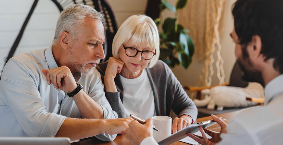 Couple meeting with financial advisor to discuss retirement tax planning strategies.